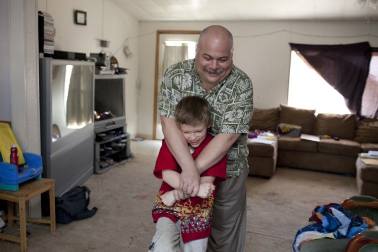 Bill Guerrero, seen with stepson Cody Veihl, 8, earns about half what he once did.