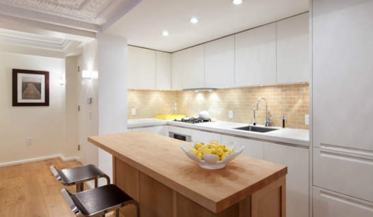 The kitchen is a study in white minimalism.