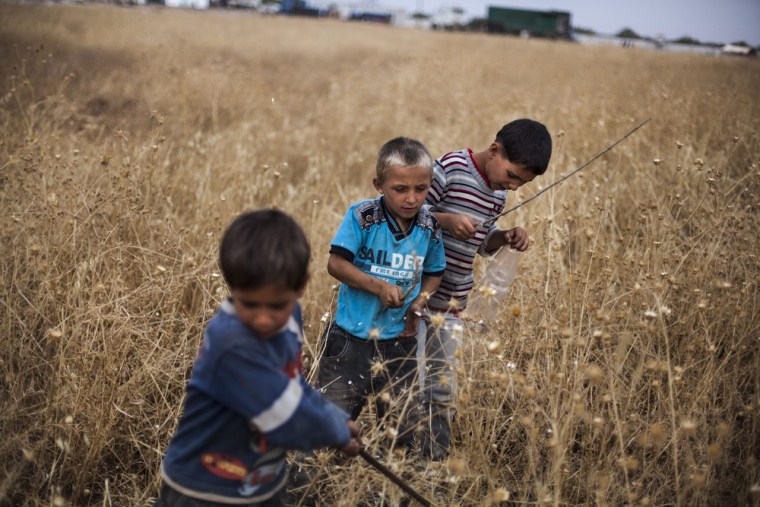 Syrian boys play near a refugee camp on the border with Turkey, near Azaz village, Syria, Sept. 30, 2012.