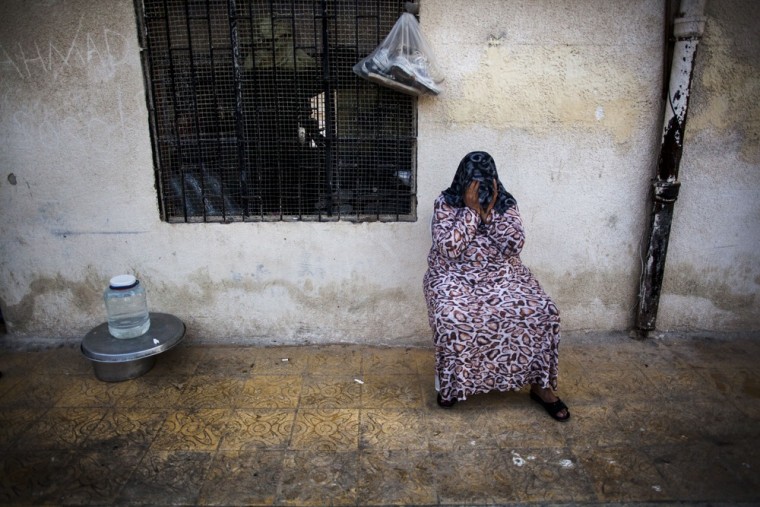 A displaced Syrian woman covers her face with a scarf in a school, where almost 15 families from Homs are living, in Souran, Syria, Oct. 1, 2012.