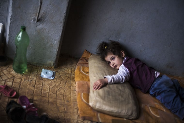 Rada Hallabi, 4, who is sick with diabetes, lies on a blanket in a refugee camp on the border with Turkey, near Azaz village, Syria, on Sept. 30, 2012.