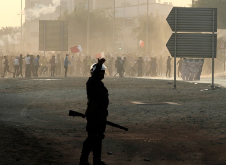 Bahraini anti-government protesters throwing stones and petrol bombs and carrying national flags clash with riot police firing tear gas and water cannons on the outskirts of the capital of Manama, Bahrain, on Tuesday, Oct. 2, 2012.