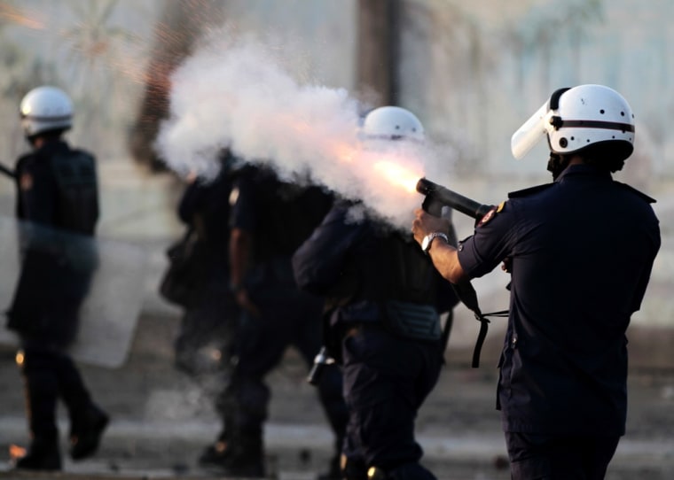 Riot police fire tear gas as they chase Bahraini anti-government protesters throwing stones and petrol bombs on the outskirts of the capital of Manama, Bahrain, on Tuesday, Oct. 2, 2012.