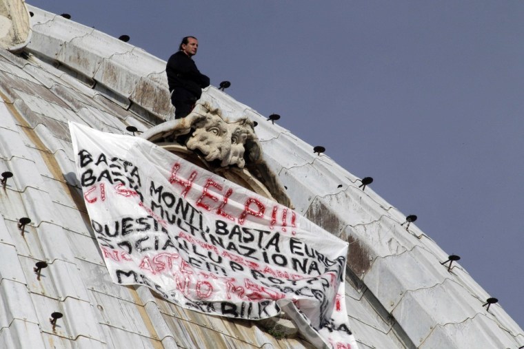 Italian businessman Marcello di Finizio stands above his banner as he protests on St. Peter's dome at the Vatican on Oct. 3, 2012.