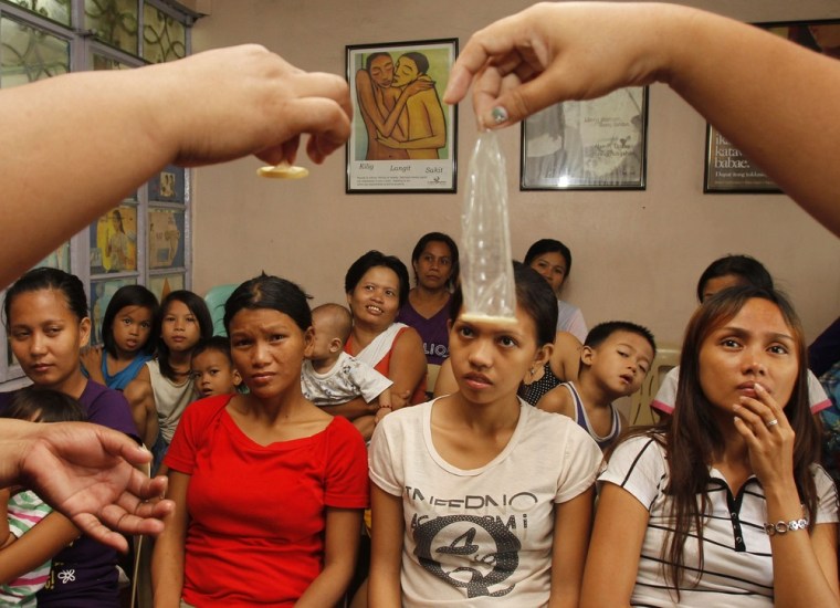 Health workers show the proper use of a condom during a family planning session held in the Likhaan centre, an NGO clinic in Tondo, Manila Aug. 6.