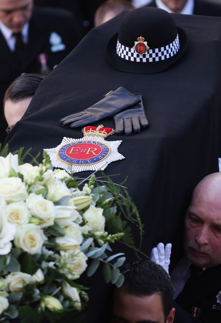 The hat and gloves of police Constable Nicola Hughes lay on top of her coffin as it is carried out of Manchester Cathedral after her funeral service on Oct. 3.
