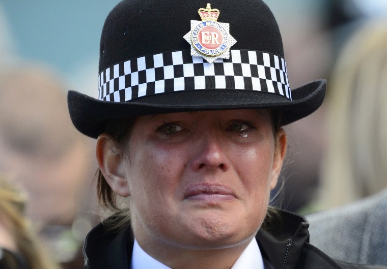 A police officer cries as the coffin of Police Constable Nicola Hughes is carried into Manchester Cathedral for her funeral service in Oct. 3.