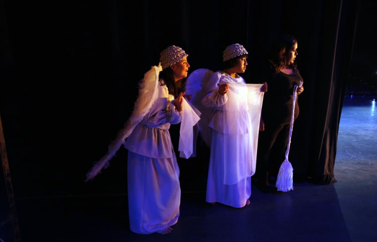 Actresses wait for their turn to walk on stage during a performance of