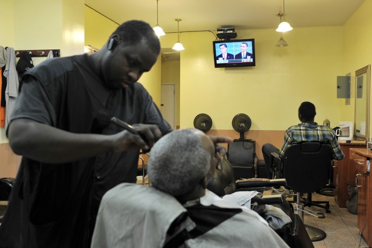 A customer gets a shave as they watch the debate on a television at the USA 1st Stop Barber Shop & Hair Salon in the Harlem section of New York.
