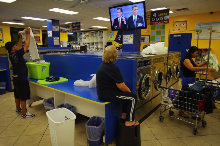 People at the Lavanderia coin laundry watch as U.S. President Barack Obama and Republican presidential candidate and former Massachusetts Governor Mitt Romney are seen during their televised debate on Oct. 3, 2012 in Miami, Florida. The telecast is the first of four debates for the 2012 Election, three Presidential and one Vice Presidential.