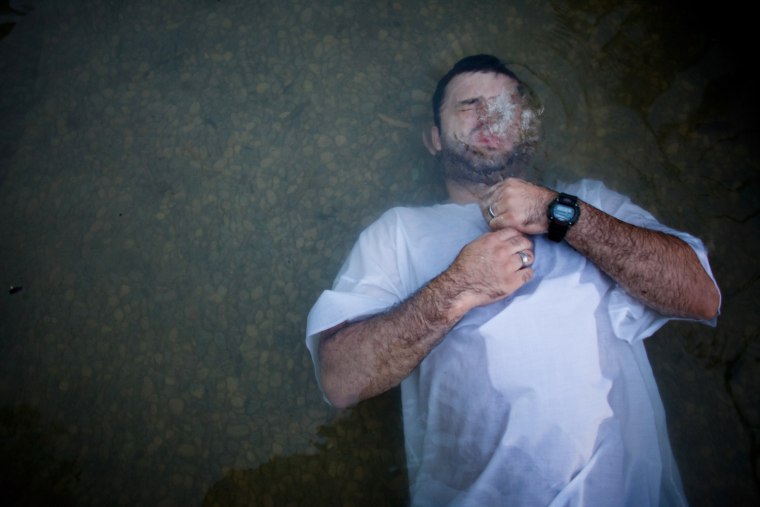 A Christian pilgrim immerses himself in the waters of the Jordan River at Yardenit in northern Israel, Oct. 3.