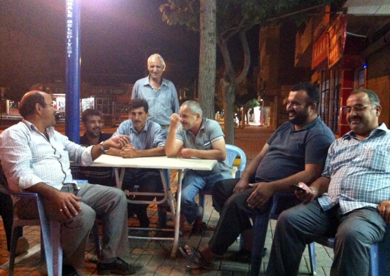 Emin Belgin, a truck driver (second from right), enjoys a rare peaceful evening at a sidewalk cafe in Akcakale, Turkey. The city is located seven miles from the Syrian border.
