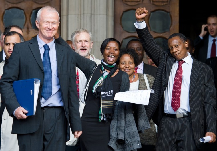 Lawyer Martyn Day, left, Agnes Gitau, daughter of a Mau Mau veteran, center, and other supporters of three Kenyans who were tortured by British colonial authorities celebrate as they leave the High Court in London on Friday after the group won the right to proceed with their legal claims against the U.K. government.