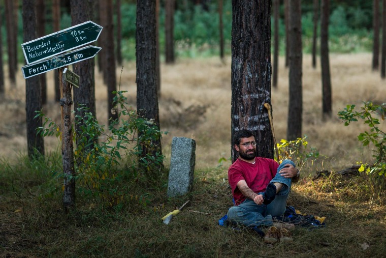 Turkish refugee Turgay Ulu removes his sock during a break in the protest march on October 3, 2012. Ulu, who said he was jailed in Turkey for his political convictions, is writing a blog about his experiences during the journey.