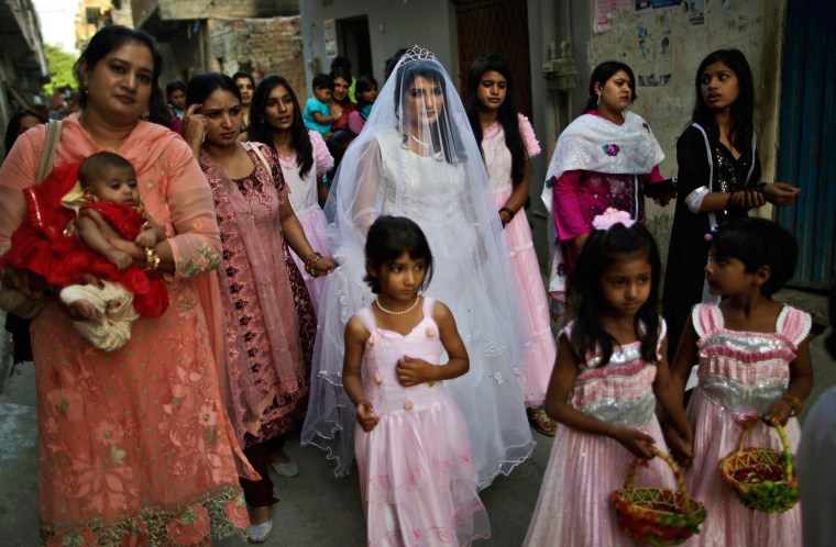 Pakistani bride Shabana Gill, 20, is flanked by relatives and friends while walking to a church for her wedding procession, in a Christian neighborhood in Islamabad, Pakistan, on Oct. 5.