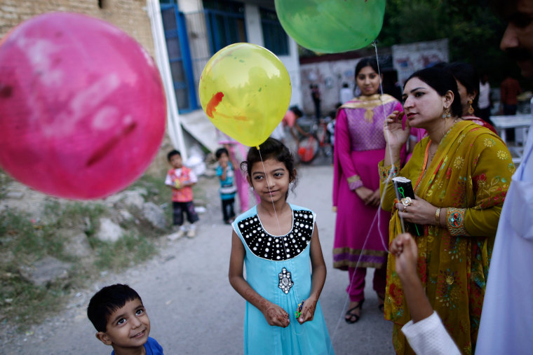Pakistani neighbors of bride Shabana Gill, 20, not pictured, wait her arrival outside a church during her wedding in a Christian neighborhood in Islamabad, Pakistan, on Oct. 5.