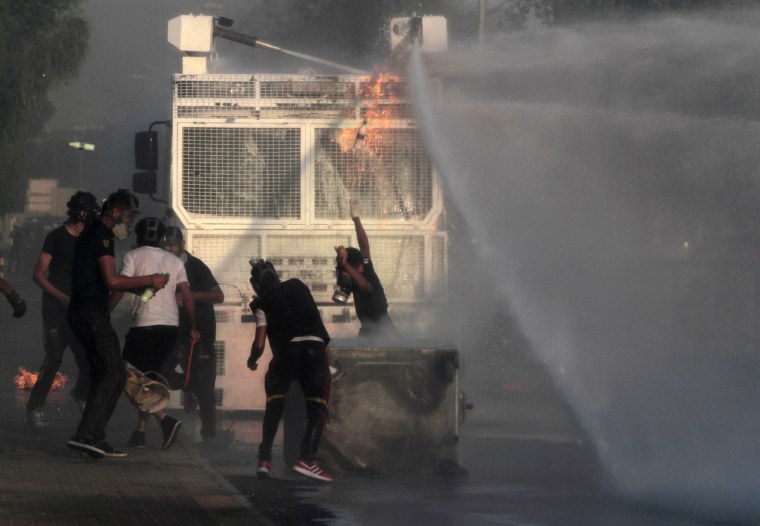 Bahraini anti-government protesters throw bottles of paint and petrol bombs at a police water cannon truck during clashes in Sanabis, Bahrain, Oct. 5.