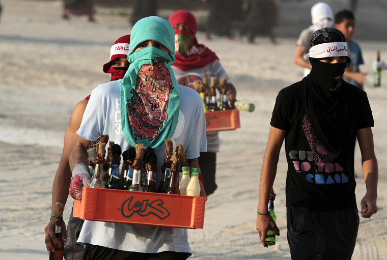 Bahraini anti-government protesters carry crates of homemade paint and petrol bombs into clashes with riot police in Sanabis, Bahrain, Oct. 5.
