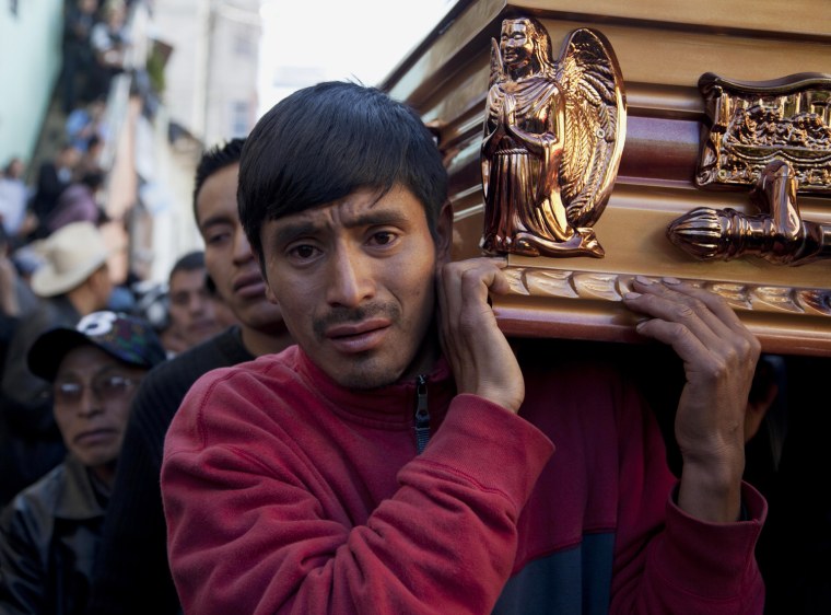 Pallbearers carry the coffin of a victim who died in clashes with security forces, through the town square of Totonicapan, Guatemala, Oct. 5, 2012.