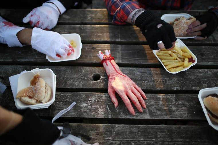 A fake hand sits on a picnic table as visitors to the Shocktober Fest enjoy a meal at Tulleys Farm on Oct. 6, in Turners Hill, England.