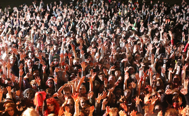 Visitors to the Shocktober Fest dressed as zombies raise their hands in unison at Tulleys Farm on Oct. 6, in Turners Hill, England.