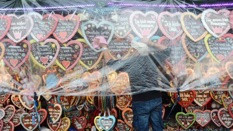 A man wipes gingerbread hearts after the rain at a booth of the Oktoberfest festival fair ground at the Theresienwiese in Munich, southern Germany, on Oct. 7, the last day of the world famous beer festival.