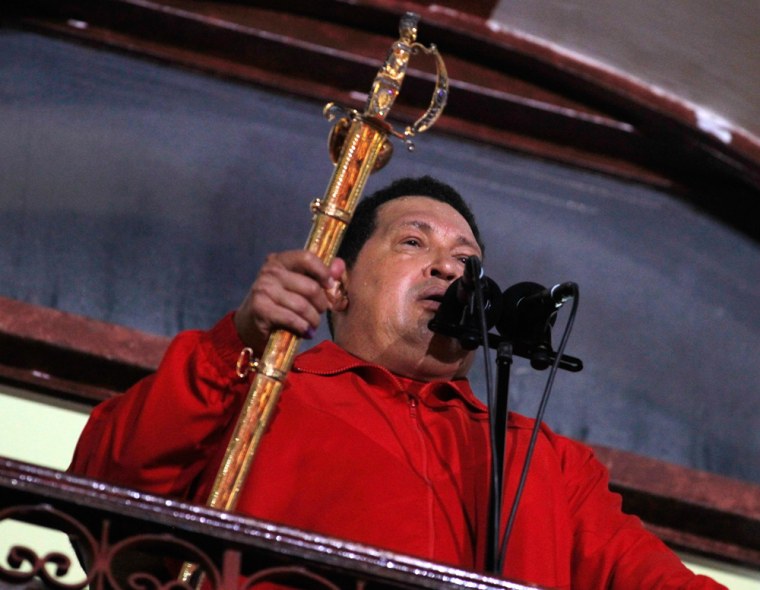 Venezuelan President Hugo Chavez holds the sword used by former military leader Simon Bolivar while celebrating from a balcony at Miraflores Palace in Caracas on October 7, 2012.