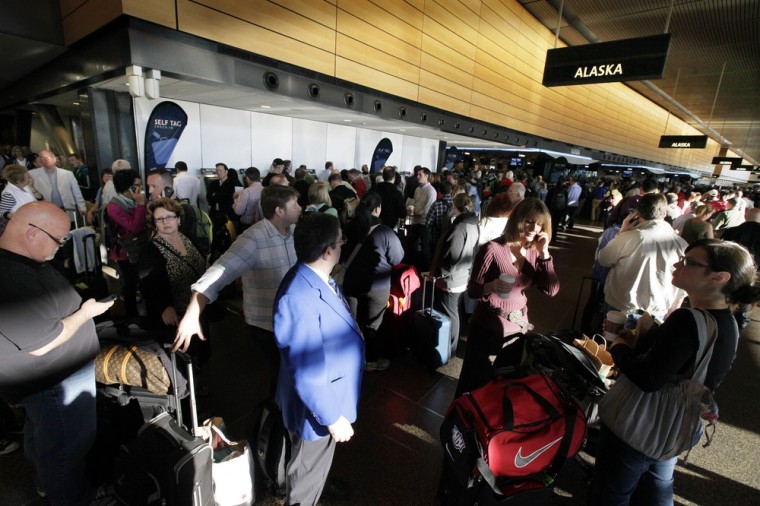 Crowds of Alaska Airlines passengers wait in long lines.