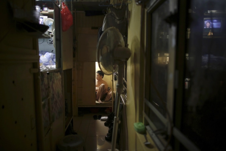Akee, 34, who works as a waiter, rests in a wooden box where he lives in Hong Kong October 9, 2012.