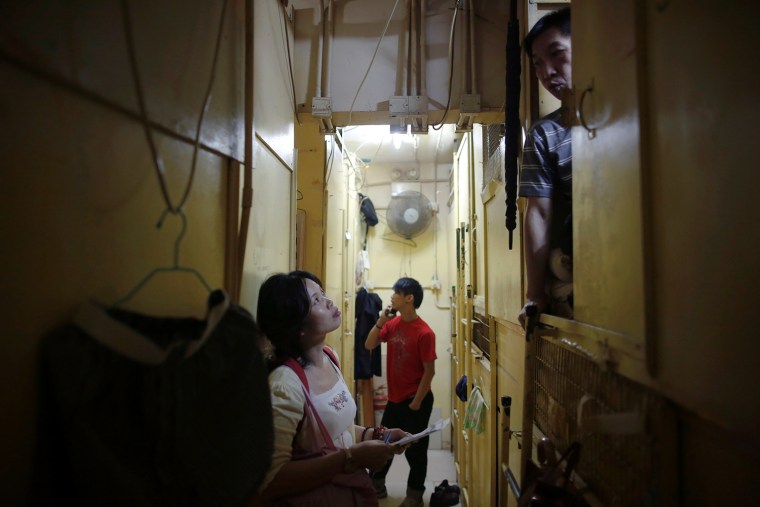 A NGO worker speaks to people living in wooden boxes in Hong Kong, October 9, 2012.