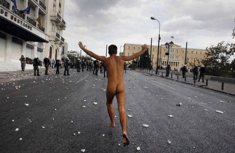 A naked protester runs past the parliament in Syntagma Square in Athens during a violent protest against the visit of Germany's Chancellor Angela Merkel October 9, 2012.