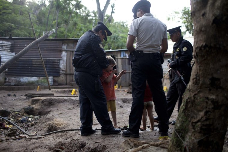 Carlos Daniel Gonzalez, 6, shows authorities the way unknown gunmen killed their parents and other relatives in the municipality of Villa Canales, Guatemala, on Oct. 9.