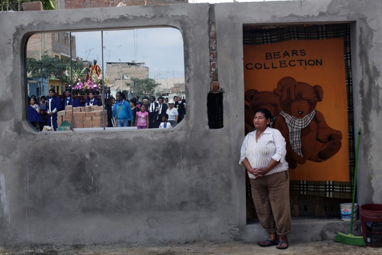 A woman watches the procession of Santa Efigenia in La Quebrada, Peru, Sept. 23.