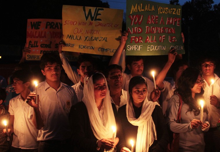 Pakistani people hold placards and candles as they pray for the well-being of Malala Yousufzai, in Lahore, Pakistan, Oct. 10. Gunmen ambushed a van carrying Malala Yousafzai and several of her schoolmates on Oct. 9 in the Swat Valley's main town of Mingora. Pakistan awarded her the first-ever National Peace Award last year in recognition for her struggle for girls education, which the Taliban banned after seizing control of the Swat valley. She was also nominated for the International Children's Peace Prize.
