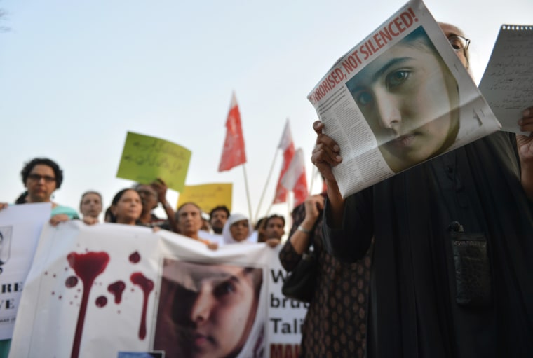 Pakistani civil society activists carry placards and papers with a photograph of the gunshot victim Malala Yousufzai during a protest rally against the assassination attempt, in Islamabad on Oct. 10.