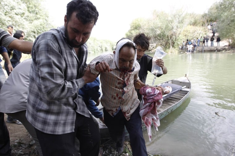 A wounded Syrian man is helped after crossing to Turkey on October 10, 2012.