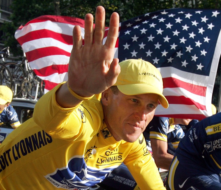 U.S. Postal Service Team rider Lance Armstrong of the United States, the first six-time winner of the Tour de France cycling classic, waves in 2004 as he cycles past a U.S. flag during the rider's parade on the Champs-Élysées in Paris.