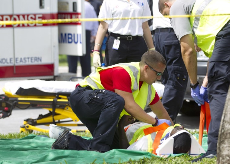 Rescue workers attend to a victim after a section of a parking garage under construction at a Miami-Dade College campus collapsed, on Oct. 10, in Doral, Fla., killing one worker and trapping at least two others in the rubble, officials said.