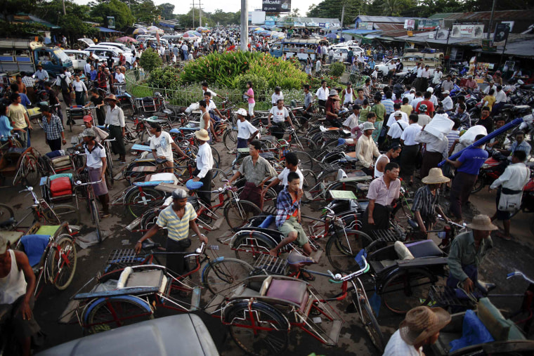 Drivers of different vehicles wait for passengers to arrive by ferry from Yangon to Dallah Township, Sept. 18. Thousands of daily migrants cross the river to Dallah using dangerous long tail boats and cheap government operated ferries. As soon as a ferry unloads passengers, hundreds of rickshaws, motorcycles, pick-up trucks and small busses start their loud performance to get people on-board. They don't leave on schedule and are often overcrowded.