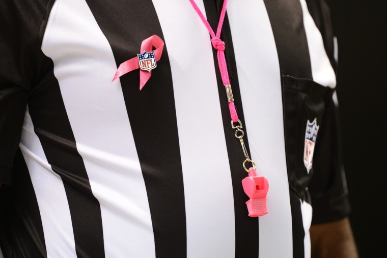 An official wears a pink ribbon and whistle for breast cancer awareness during the game between the San Francisco Giants and the Cincinnati Reds at Mercedes-Benz Superdome on October 7 in New Orleans.