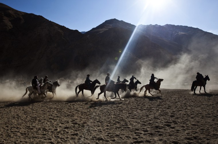 The Afghan national sport of buzkashi is played by men on horseback competing to throw a beheaded calf, goat, or sheep into a scoring circle.