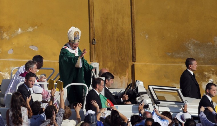 Pope Benedict XVI waves as he arrives to conduct mass.