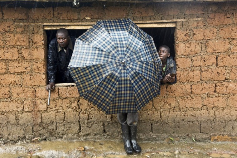 People take shelter from the rain in Rutare village.