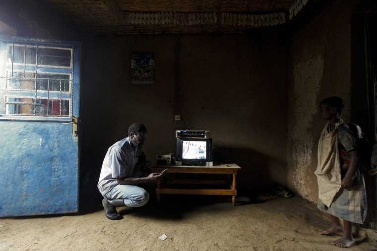 Tabaro sets up a television to play a DVD at his friend's home.