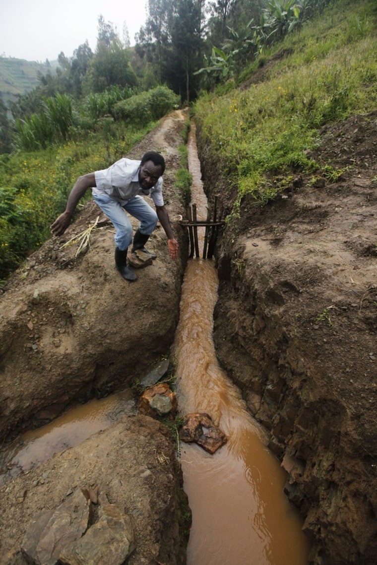 Tabaro stands next to a barrage he constructed to control the amount of water passing the dam.