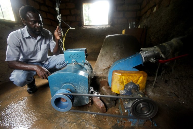 Tabaro sits next to a turbine generator he has built inside his generating station.
