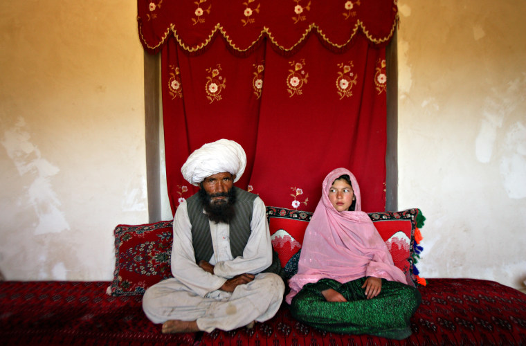 Faiz, 40, and Ghulam, 11, sit in her home prior to their wedding in the rural Damarda Village, Afghanistan on Sept. 11, 2005. Ghulam said she is sad to be getting engaged as she wanted to be a teacher.