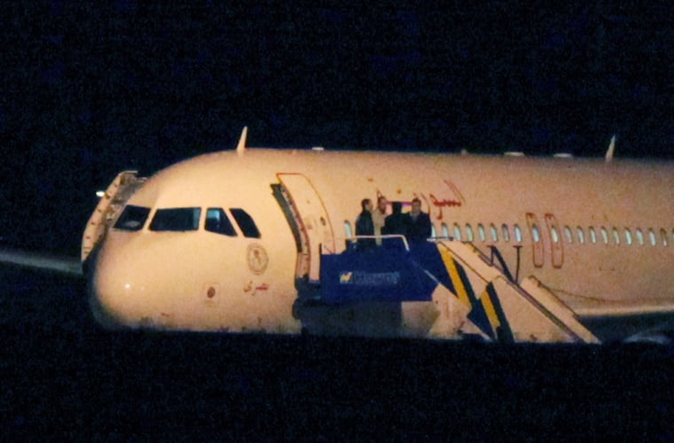 People speak from the top of the steps of a Syrian passenger plane that was forced by Turkish jets to land in Ankara, Turkey, on Thursday. Turkish jets on Wednesday forced the Syrian Air Airbus A320 passenger plane to land on suspicion that it was carrying weapons, amid heightened tensions between Turkey and Syria that have sparked fears of a wider regional conflict.