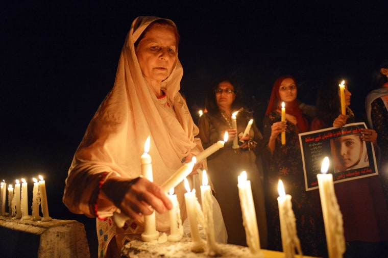 A woman lights a candle during a vigil for Malala Yousafzai in Islamabad, Pakistan, on Oct. 11.