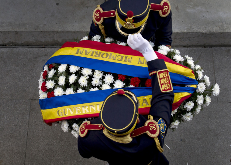 Romanian honor guard soldiers adjust their outfits before laying a wreath at the Holocaust memorial following National Holocaust Remembrance Day commemorations in Bucharest, Romania, Oct. 10.